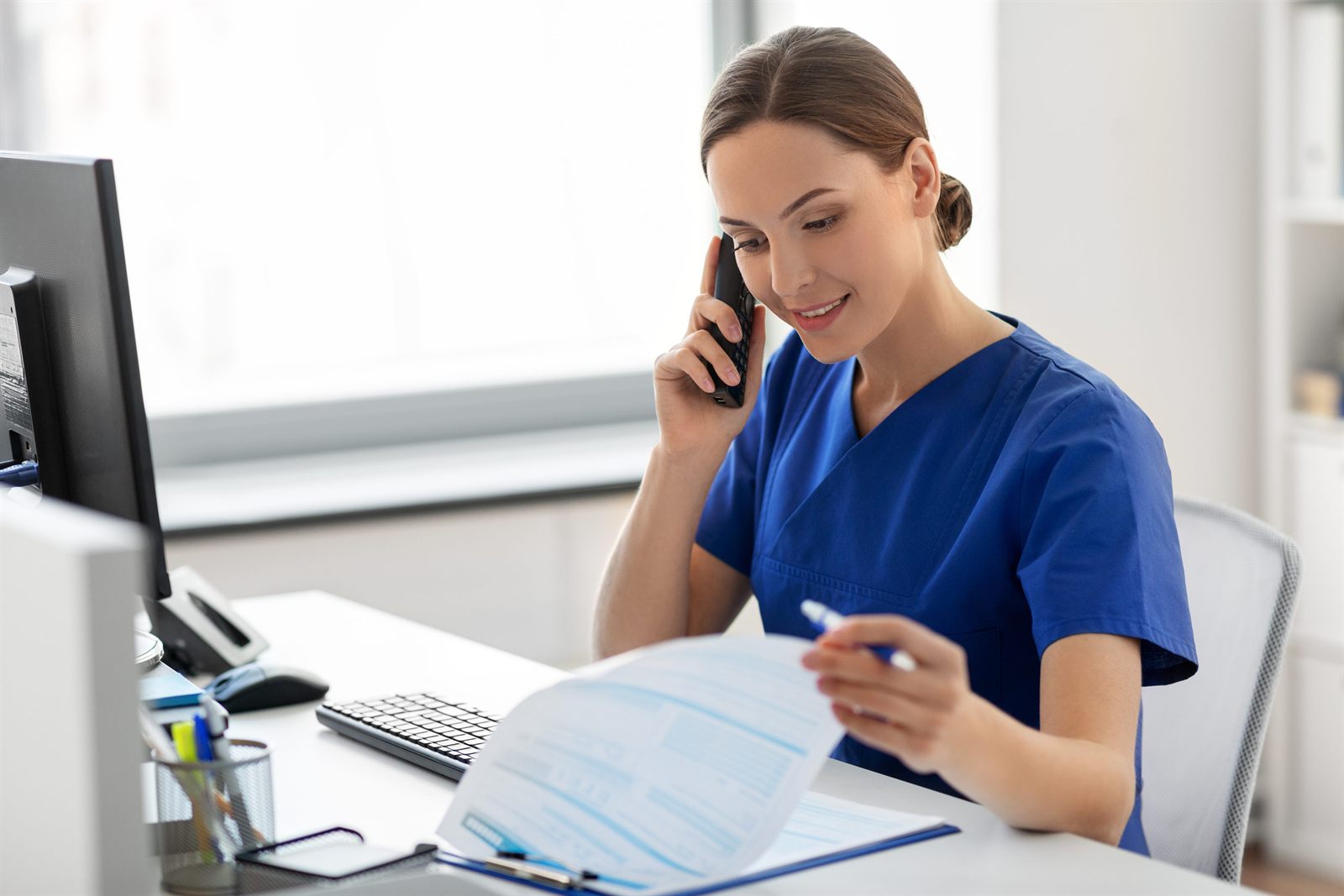 A Care Plus care coordinator answering a call at her desk